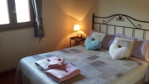 a bed with a white comforter and pillows at La Trucha del Arco Iris in El Acebo de San Miguel