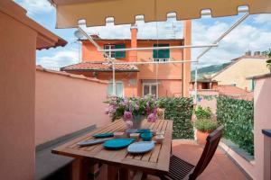 a wooden table with blue dishes and flowers on a balcony at Casa al Castello in Lerici
