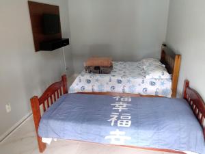 a bedroom with two twin beds with a blue blanket at Recanto dos Mineiros in Monte Alegre do Sul
