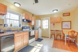 a kitchen with wooden cabinets and a table with chairs at 7 Mi to Dtwn Dayton Home in Kettering with Yard in Dayton +17 photos