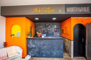 ein Restaurant mit orangefarbenen Wänden und einer schwarzen Theke in der Unterkunft Anchi Guesthouse in Dubrovnik