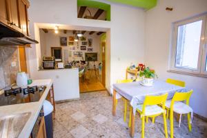 eine Küche und ein Esszimmer mit einem Tisch und gelben Stühlen in der Unterkunft Anchi Guesthouse in Dubrovnik + 35 Fotos