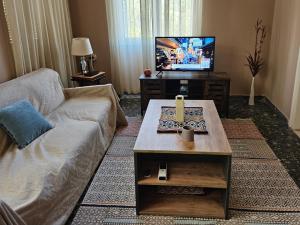 ザハロにあるCozy Stone House in Central Zacharo - Near Beachのソファとテレビのあるリビングルーム