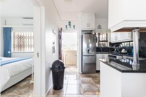 a kitchen with a stainless steel refrigerator and a bed at Luxury Ocean View Escape with Private Rooftop -Sancta Maria in Kingsborough