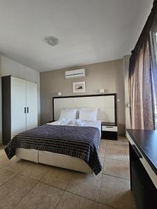 a bedroom with a bed with a black and white comforter at Rodolithos Beach in Stavros