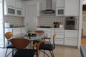 里耶卡Kuća za odmor Vila Elza的厨房配有玻璃桌和椅子