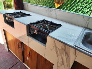 eine Küchentheke mit Herd und Spüle in der Unterkunft Hotel J.B. in Zihuatanejo