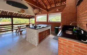a kitchen with an island in the middle of a room at Casa Aconchego Canto da Viola in São Roque