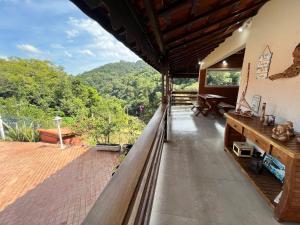 a balcony of a house with a view of the mountains at Casa Aconchego Canto da Viola in São Roque
