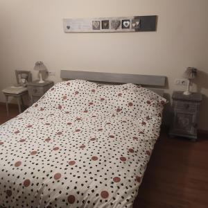 a bed with a polka dot bedspread with hearts on it at La maison des trois frontières in Wolschwiller
