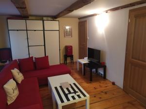 a living room with a red couch and a tv at La maison des trois frontières in Wolschwiller