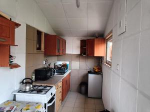 a small kitchen with a stove and a refrigerator at Domek letniskowy Lipsk saperów 42 in Lipsk