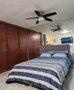 圣胡安Walking beach distance studio in Miramar San Juan的带床和吊扇的卧室