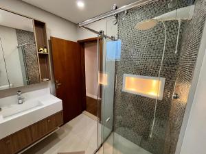 a bathroom with a glass shower and a sink at Casa Aconchego Canto da Viola in São Roque +20 photos