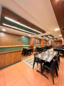 a restaurant with tables and chairs and a bar at City Palace Hotel in Ooty