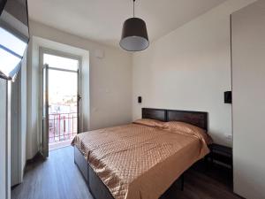 una camera da letto con un letto e una grande finestra di Le dimore di Traiano a Civitavecchia