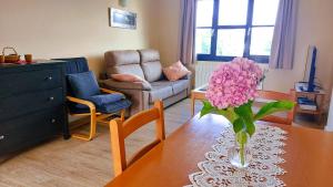 a living room with a vase of pink flowers on a table at Duplex Colombres in Colombres