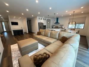 ein Wohnzimmer mit großer Couch und Küche in der Unterkunft Bear Port Cabin Getaway in Big Bear City Airport