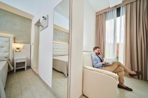 a man talking on a cell phone in a hotel room at Hotel Bristol in Bellaria-Igea Marina +83 photos