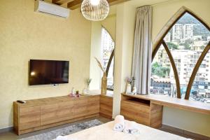 a bedroom with a tv and a large window at Apartment in Jounieh - J707 in Al Bāţiyah +17 photos