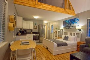 a bedroom with a bed and a table and a kitchen at Tide and Trail- Cabin in Ucluelet in Ucluelet