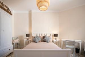 a white bedroom with a large bed with two tables at Maltese Charm - Seaside Stay - Table Soccer in St. Julianʼs