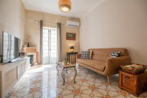 a living room with a couch and a tv at Maltese Charm - Seaside Stay - Table Soccer in St. Julianʼs
