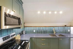 uma cozinha com armários verdes, um lavatório e um micro-ondas em Raven Lady #202- Ucluelet, Sleeps 4, Pet Friendly em Ucluelet