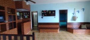 a room with a brick wall and a bench at Casa de Junqueira Mangaratiba in Mangaratiba