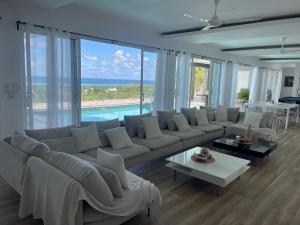 a living room with a large couch and a pool at Villa Pierre in Las Terrenas