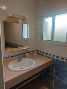 a bathroom with a sink and a mirror at chalet la rose des sables in Labenne +17 photos