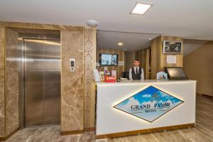 a man is standing at a grand rairie hotel counter at Grand Pamir Hotel in Istanbul