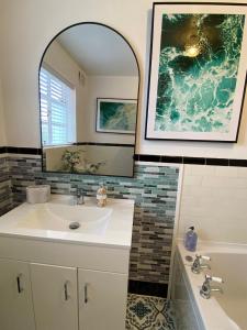 a bathroom with a sink and a mirror and a tub at Gallery Apartment in Stratford-upon-Avon +19 photos
