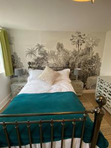 a bedroom with a bed with a blue comforter at Gallery Apartment in Stratford-upon-Avon