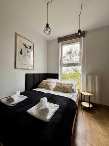 a bedroom with a large bed with towels on it at Apartament Kamionka Piast in Opole +27 photos