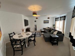 a living room with a couch and a table at Tardis Townhouse - Spacious and Comfortable in Derby
