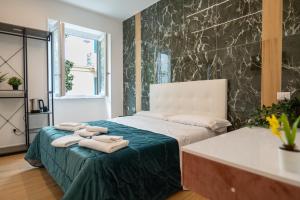a bedroom with a bed with towels on it at Relais San Demetrio - Modern & Central rooms in Salerno