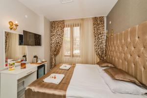 a bedroom with a large bed and a desk at Grand Pamir Hotel in Istanbul