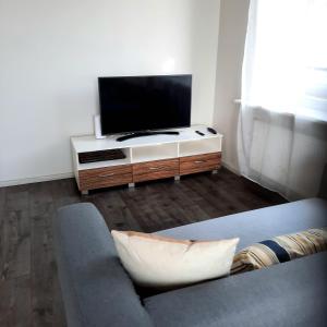 a living room with a couch and a flat screen tv at Charming Old Town Retreat in Rīga