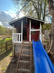 un parco giochi con scivolo e una casetta per i giochi di Ferienzimmer Teiselsmühle Gehren Heideblick a Heideblick Altre 14 foto