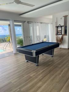 a pool table in a living room with a view of the ocean at Villa Pierre in Las Terrenas