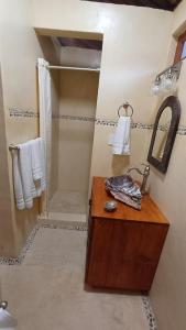 La salle de bains est pourvue d'une douche et d'une table en bois avec un lavabo. dans l'établissement Lovely Cottage at La Ropa Beach, à Zihuatanejo 5 autres photos