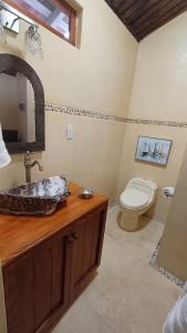 une salle de bain avec un lavabo et des toilettes dans l'établissement Lovely Cottage at La Ropa Beach, à Zihuatanejo
