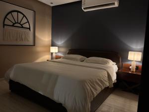 a bedroom with a large white bed with two lamps at Cali chalets in Riyadh +23 photos