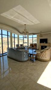 a living room with a large couch and a table at قصر تل الرمان in Ar Rummān