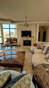a large living room with couches and a fireplace at قصر تل الرمان in Ar Rummān
