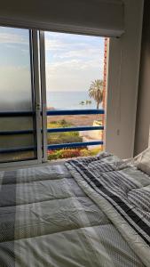 a bedroom with a bed and a view of the beach at Alquiler Apartamento Vacacional con Vista al Mar, Isla de Margarita in Porlamar