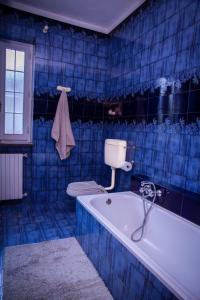 a blue tiled bathroom with a tub and a toilet at La Quiete in Caraglio