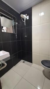 a black and white bathroom with a toilet and a sink at Casa próxima ao Forum in Pouso Alegre +21 photos