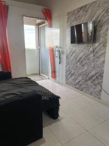 a bedroom with a shower and a bed in a room at Loft 11, caminho do mirante in Iguaba Grande +5 photos